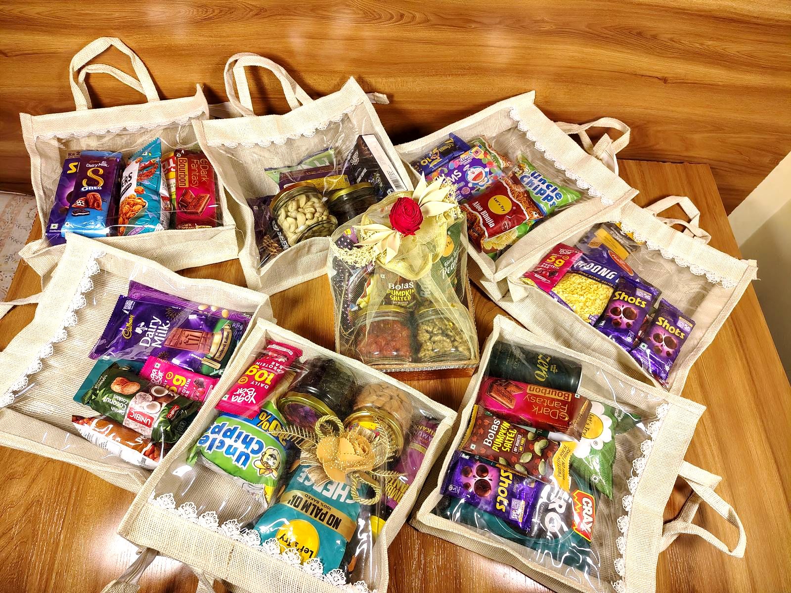 Assorted festive gift hampers and jute treat bags packed together, ready for corporate gifting